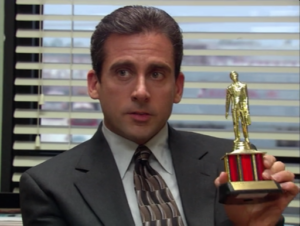 Micheal Scott holding a trophy.